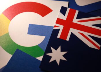 Google is striking deals in Australia to pay for journalism but Facebook is vowing to restrict news sharing. Soft focus image of google logo and Australia flag.